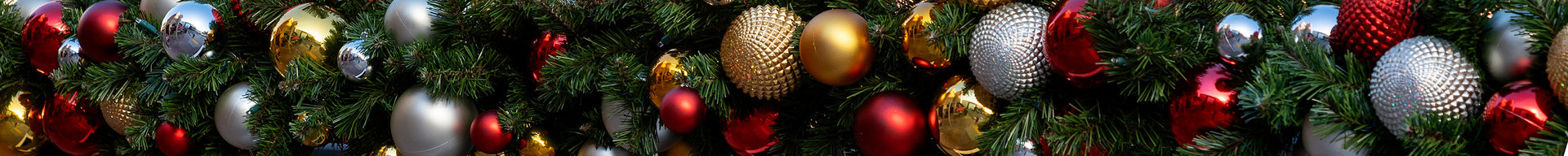 Close-up of a commercial Christmas tree decorated with red, gold, and silver ornaments.