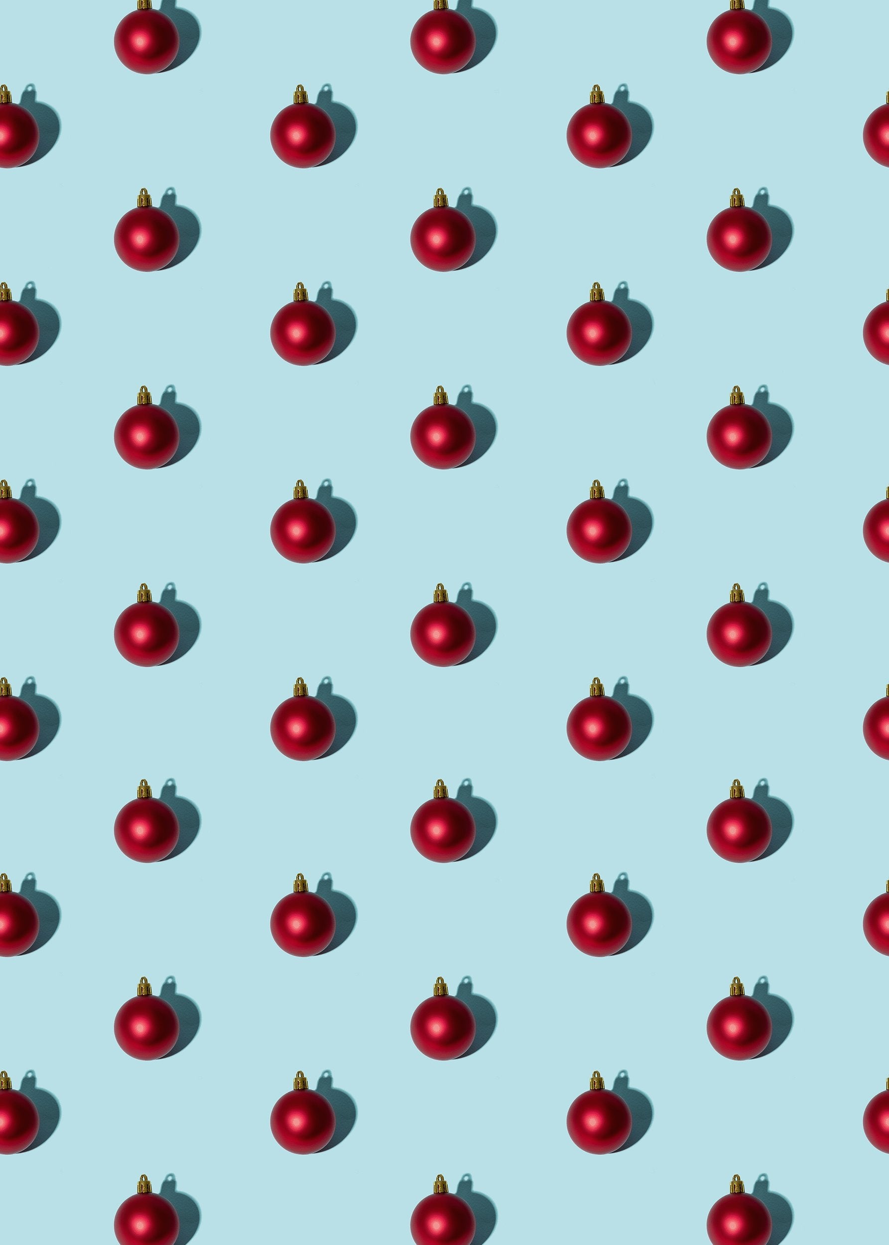 Rows of red Christmas ornaments on a blue background