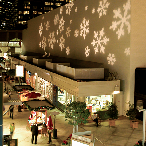 Projector displaying snowflakes on the wall on a department store.