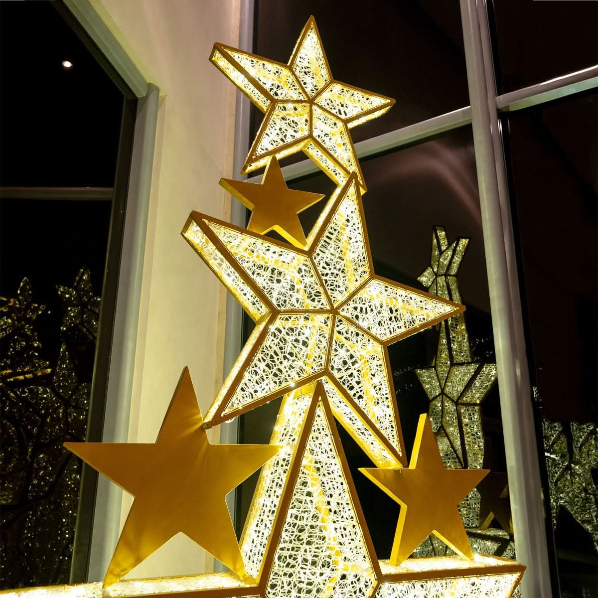 Dekra-Lites Lapua Star Stack, inside a building & illuminated at night.