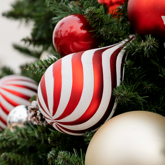Dekra-Lite Red & White Swirl Waterdrop Ornament on tree