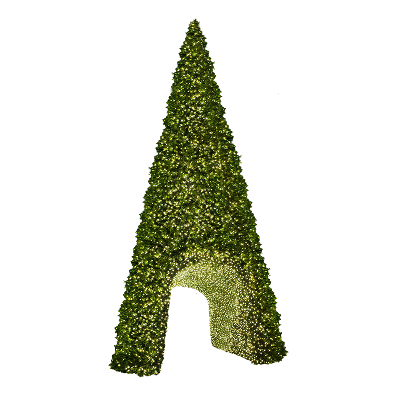 A large 40' Sequoia Tree, with a wide base and narrow top. The tree is decorated with many strands of warm white lights. The center of the tree is hollowed out to create a tunnel-like opening. The tunnel is decorated with lights, creating a winter wonderland scene.