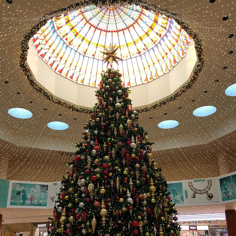 Giant decorated Christmas tree beneath an illuminated circular canopy