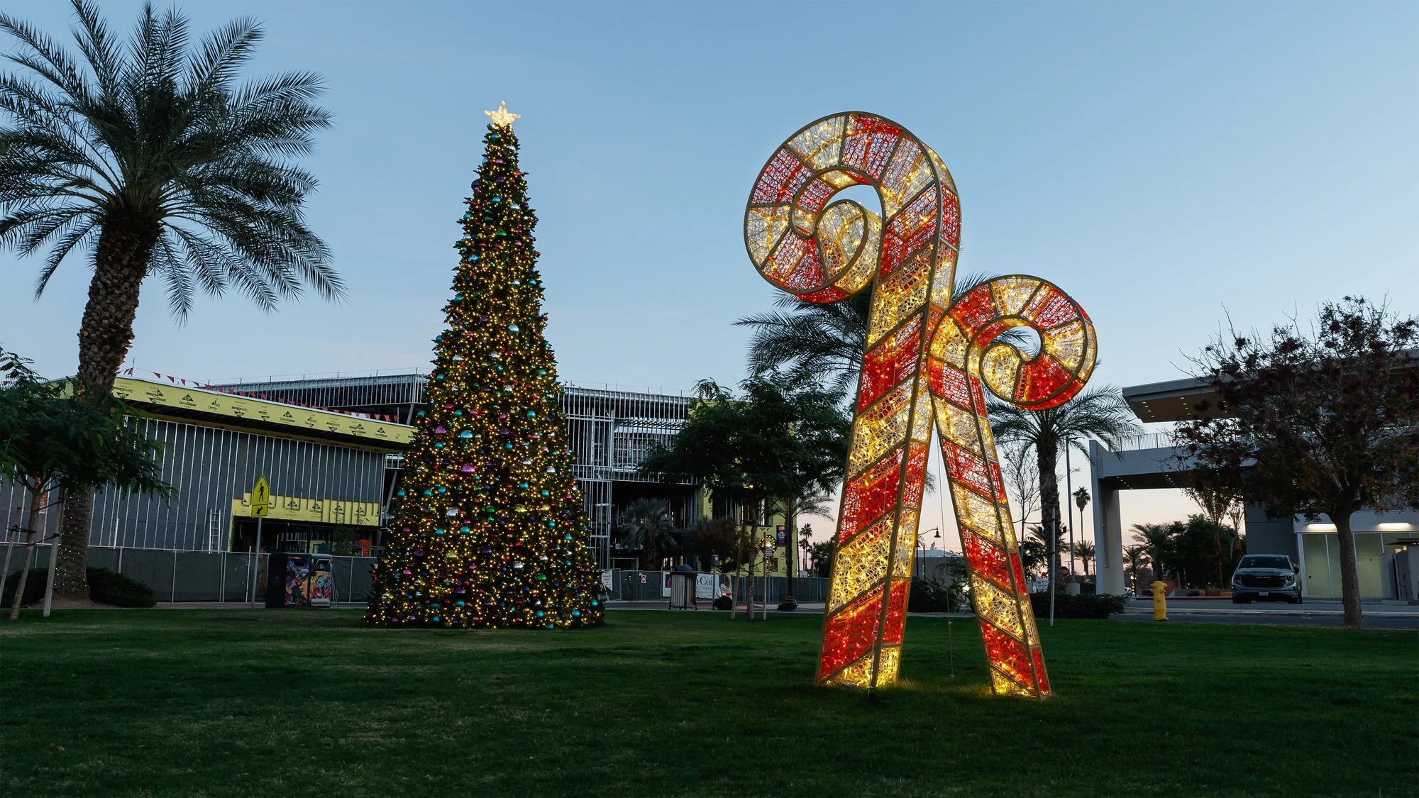 Illuminated Christmas tree and oversized candy canes in a city public space
